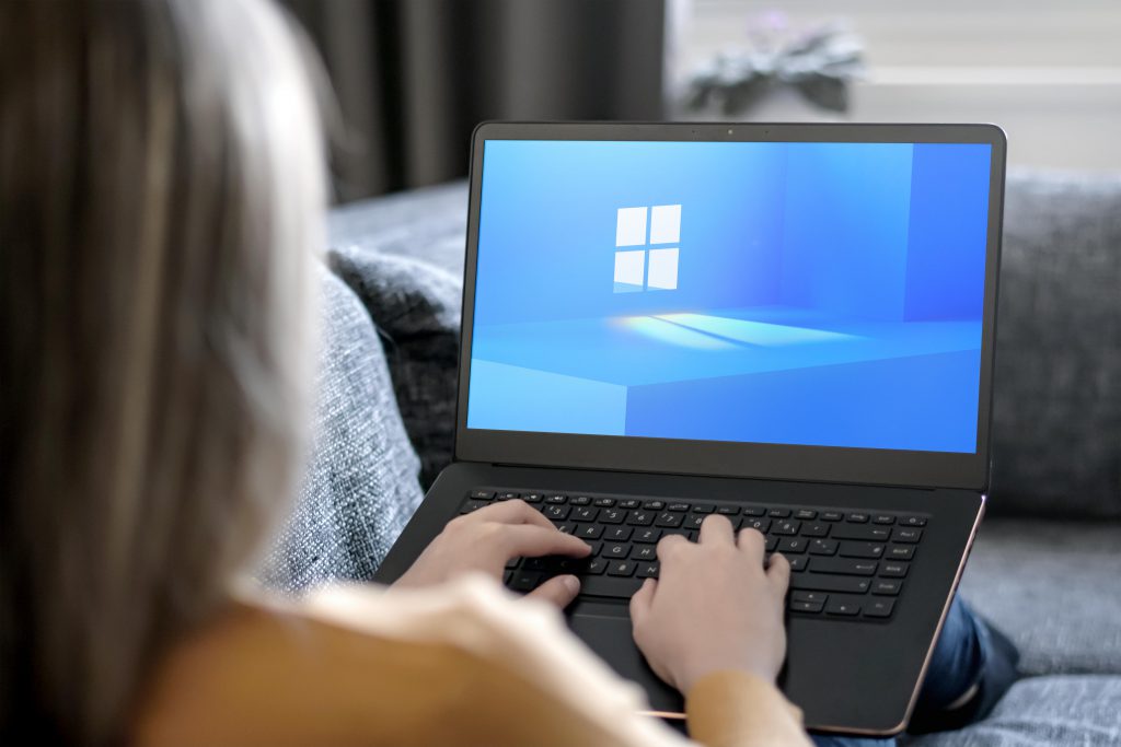 Frau arbeitet am Laptop. Auf dem Display ist das neue Windows-Design zu sehen.