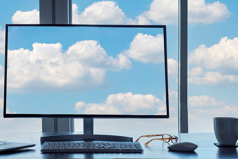 Bildschirm mit Wolkenabbildung vor Fenster mit blauem Himmel und Wolken