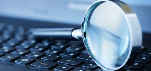 Lupe liegt auf Laptop Tastatur