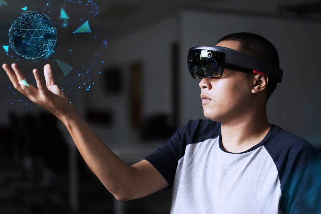 Mann hat VR-Brille auf und hält eine virtuelle Kugel in der Hand